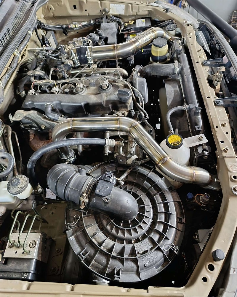 Polished custom stainless boost pipes in a modified engine bay
