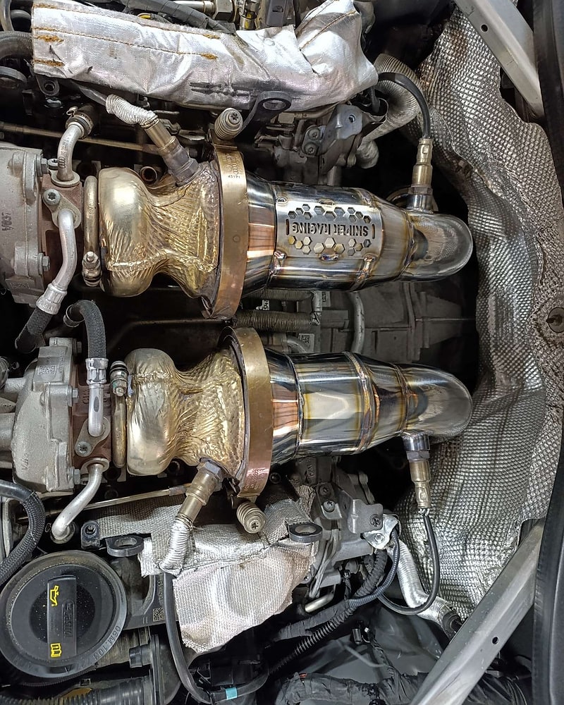 Twin SNIPER Racing high-flow downpipes installed in a performance vehicle