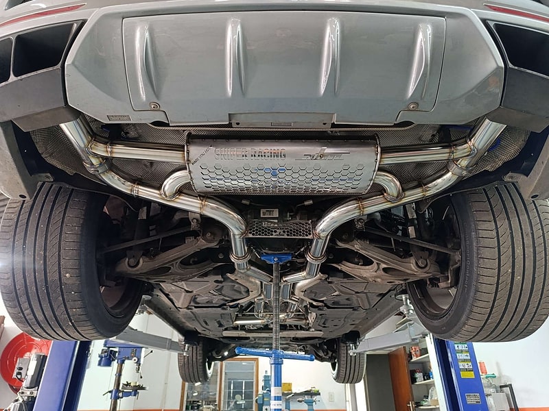 Complete custom stainless exhaust installed under a performance vehicle